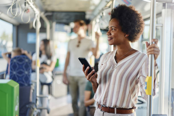 istock Happy African American woman using cell phone in a bus. 2004546556
