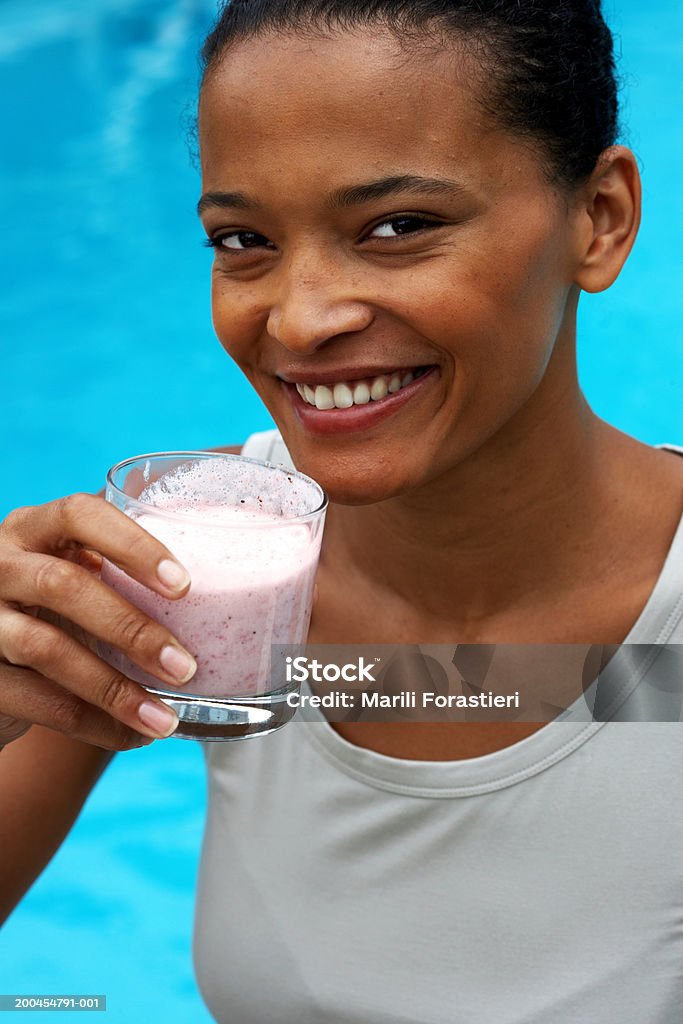 Jovem mulher com bebidas sorriso, retrato, close-up - Foto de stock de 20-24 Anos royalty-free