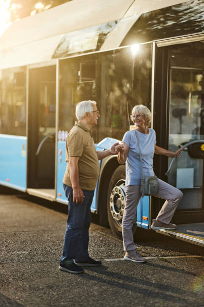 istock Happy senior woman talking to her husband while entering the bus. 2004553571
