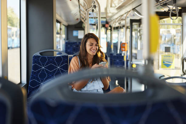 istock Happy woman using mobile phone in a public transport. 2004555698