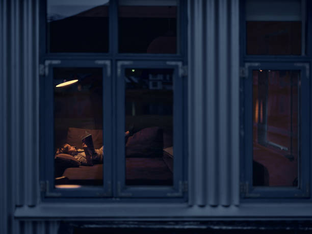 istock Little boy reading a book while relaxing in the evening at home. 2004569181