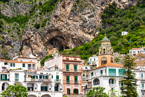 Looking at the famous Santa Maria Assunta church at the village of Positano on the Amalfi coast. Many of the small villages along the Amalfi coastline are hundreds of meters above sea level, because of the geographical reasons. The Amalfi coast is a stretch of coastline on the northern coast of the Salerno Gulf on the Tyrrhenian Sea, located in the Province of Salerno of southern Italy. The Amalfi Coast is a popular tourist destination for the region and Italy as a whole, attracting thousands of tourists annually. In 1997, the Amalfi Coast was listed as a UNESCO World Heritage Site.