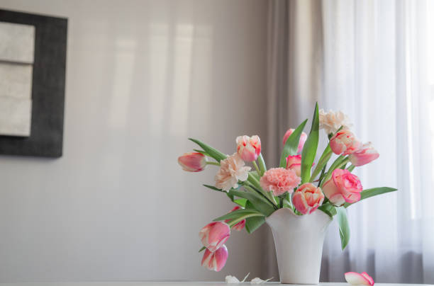 istock pink spring flowers in white ceramic vase in modern home interior 2004581391