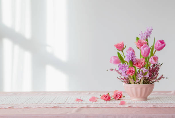 istock pink flowers in vase on background white wall 2004581420