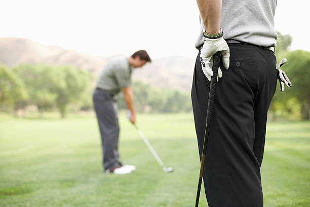 Two men playing golf, one standing in foreground  clear sky usa tree day stock pictures, royalty-free photos & images