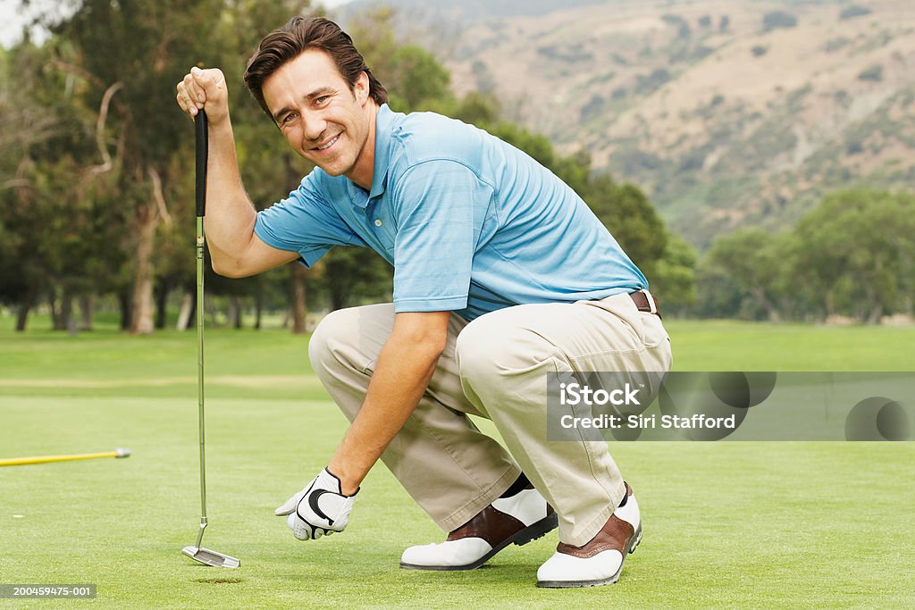 Golfspieler der Kniebeuge auf Grün - Lizenzfrei Hockend Stock-Foto