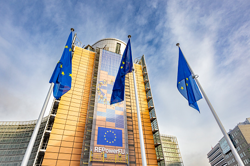 Brussels, Belgium – February 24, 2023: The flags of the European Union in front of the European Commission building in Brussels, Belgium