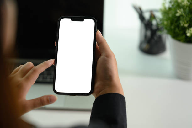 istock Female worker using mobile phone at her office desk. Closeup, blank screen for your advertising text. 2004609989