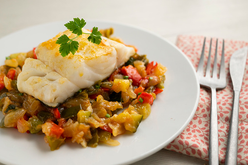 Cod tapa cooked with vegetables in samfaina. Traditional recipe of Spanish gastronomy..