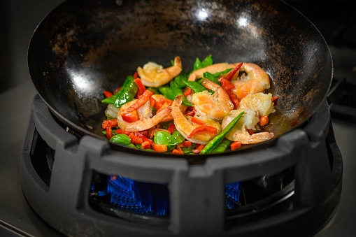 Close-up of prawn with vegetable cooking in pan.