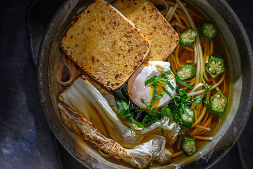 Close-up tofu noodle with vegetable in bowl on table.