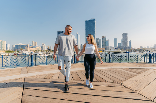 Young couple holding hands while walking near Souq Sharq in Kuwait City In Kuwait.