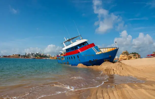 Photo of Stranded fishing boat in Praia Grande beach, Ferragudo, Lagoa, Algarve, Portugal