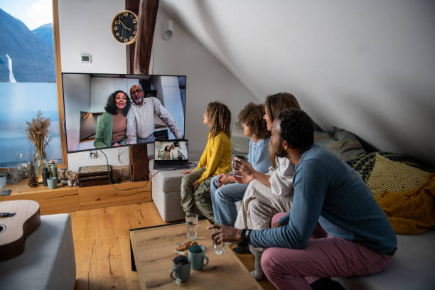 People, family and technology concept. Happy father with multiethnic children having video call with their grandparents stock photo