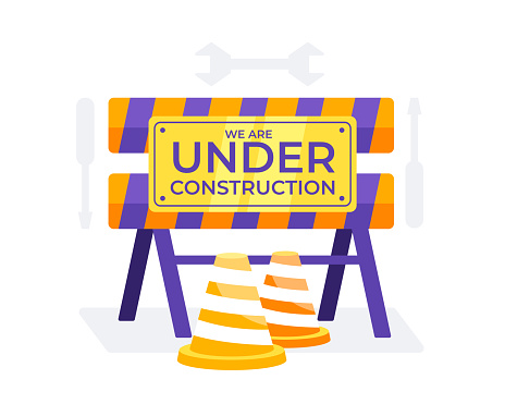 Under Construction sign with orange and white traffic cones and construction barriers.