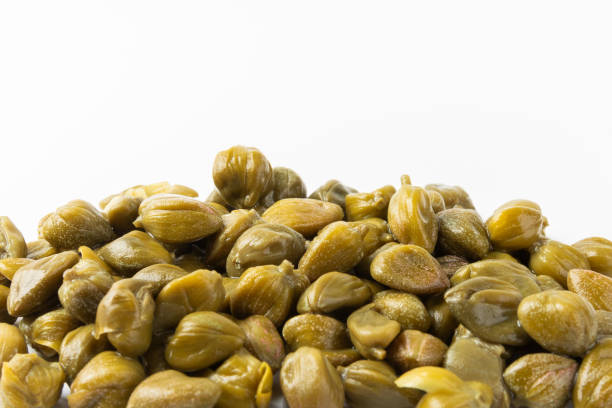 istock Capers isolated on white background. Marinated caper buds, small salted capparis in bowl, fermented food, pickled capers group.Organic spices and seasonings. 2004658428