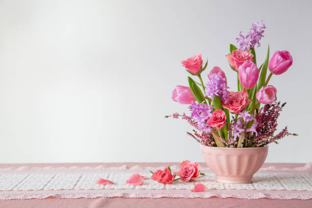 istock pink flowers in vase on background white wall 2004667136