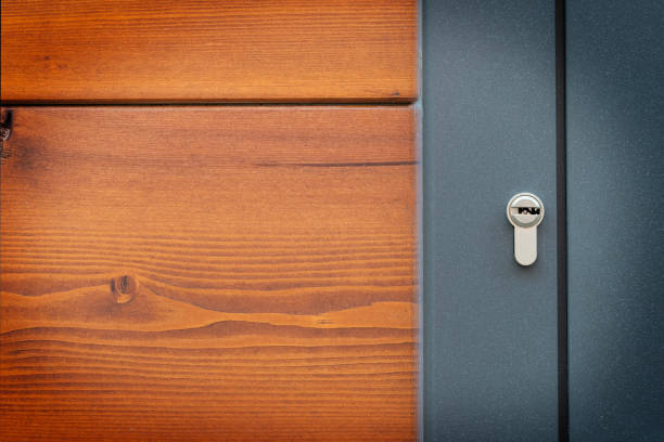 New house keys sit on a wooden counter.