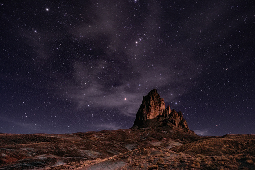 The scenic view of Agathla Peak against the backdrop of a starry sky. Monument Valley, Arizona