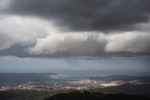 Dramatic landscape with copy space in the sky of the border between Spain and France in the Basque Country. Hondarribia, Irun, Behobia and Hendaye cities separated by Bidasoa river.