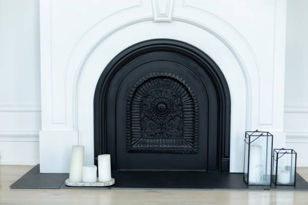 istock White fireplace in interior design Scandinavian living room. Decorative black white fireplace with candles on floor in interior room at home 2004681892