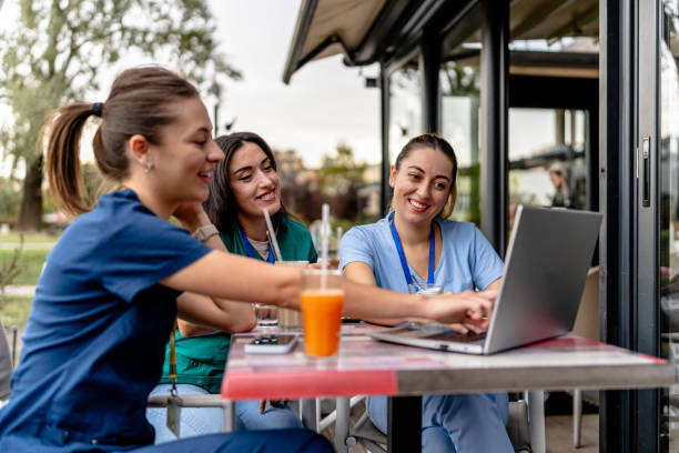 Nurses share laptop session in outdoor cafe