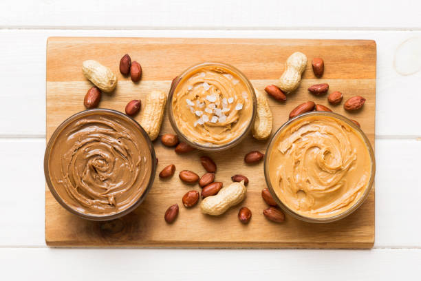 istock Glass jar with peanut butterin plate on table background, top view space for text and close up 2004684056