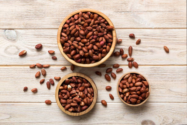 istock Fresh healthy peanuts in bowl on colored table background. Top view Healthy eating bertholletia concept. Super foods 2004684604