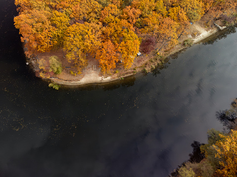 Aerial look down view on river with colorful autumn trees on riverbanks