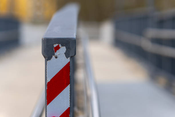 Warning red and white striped line tape, trespassing forbidden, hazardous area sign. Clear blue sky background. Galicia, Spain.