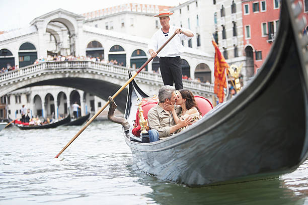 italia, venecia, par montar, besando a la góndola - couple mature adult europe travel fotografías e imágenes de stock