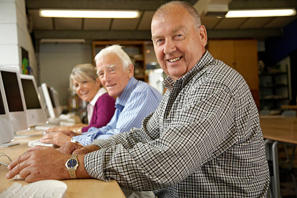 ältere frau und zwei männer in computer-klasse, porträt - horizontal female with group of males posing looking at camera stock-fotos und bilder