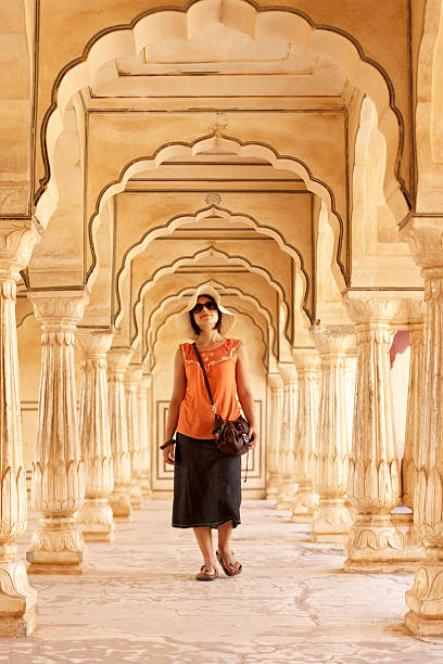 India, Rajasthan, Amber Fort, woman walking through archways in palace stock photo