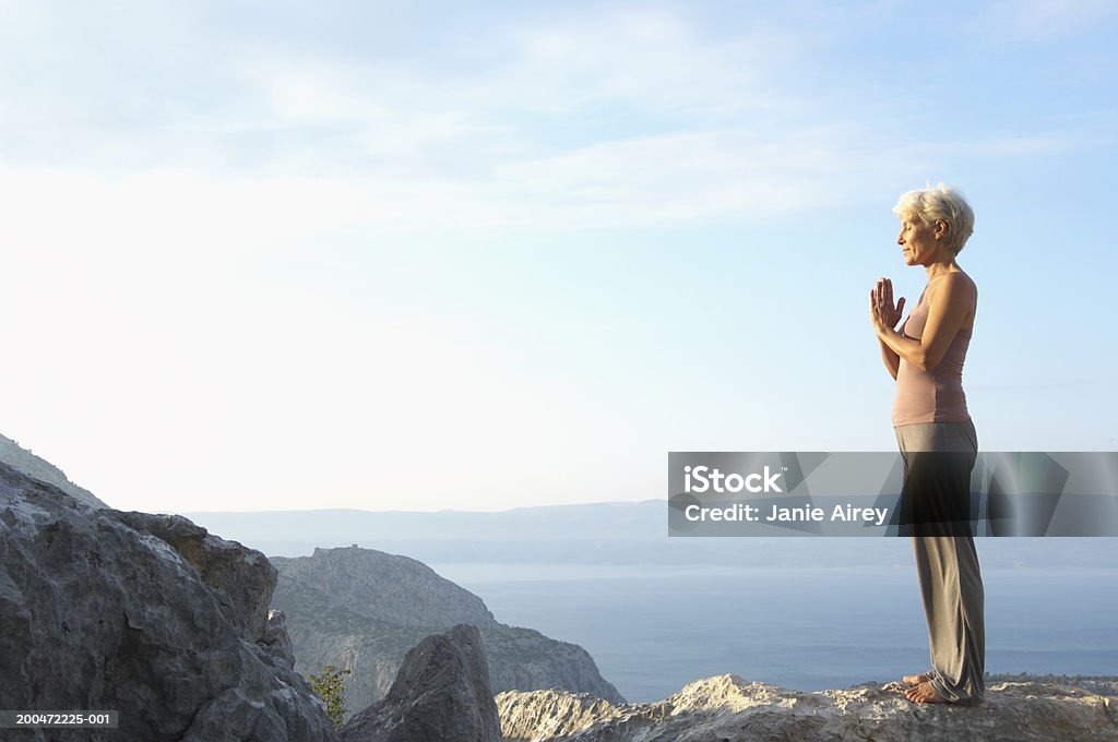 Mature woman with hands pressed together in mountain landscape Croatia Mountain Stock Photo