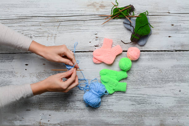 istock woman hands knitting tiny baby socks 2004724733