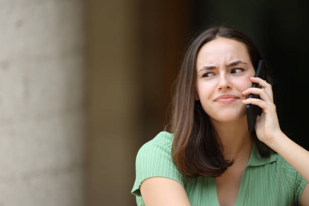 istock Distrustful woman talking on phone 2004726850