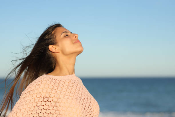 istock Woman at sunset breathing on the beach 2004728604