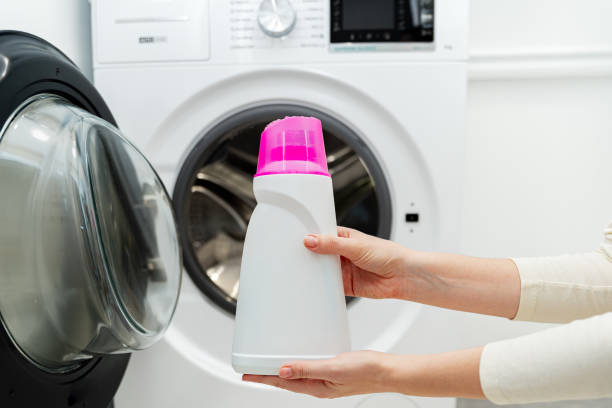 istock Person adding liquid laundry detergent to the washer, close up 2004749009