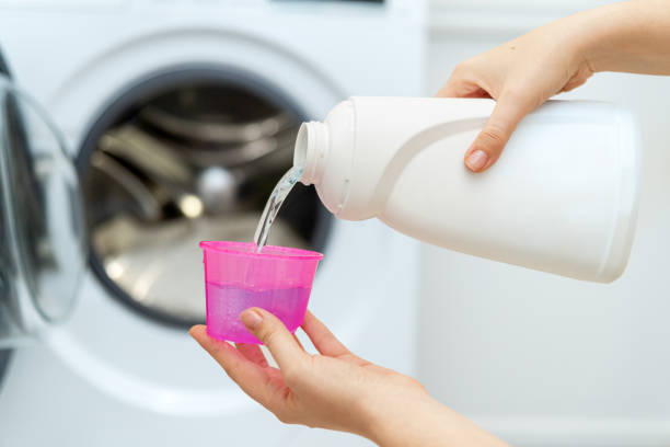 istock Person adding liquid laundry detergent to the washer, close up 2004750065