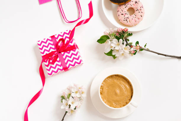 A cup of hot chocolate with a heart shaped marshmallow - red satin background