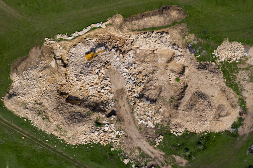 Aerial drone view of excavator working in a limestone quarry