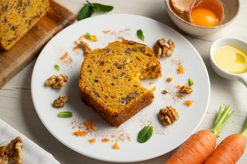 Delicious and fluffy carrot cake with walnuts on a wooden board..