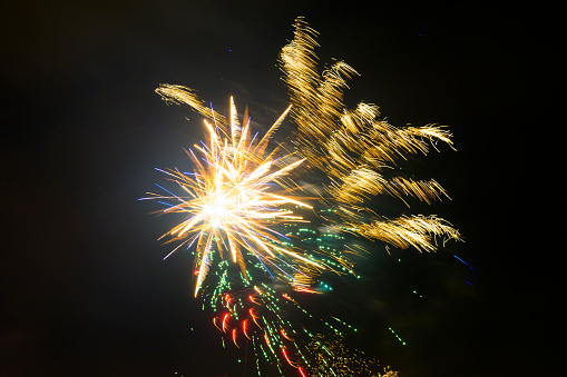 Bright and colorful fireworks expolding in the black sky during new year's celebrations.