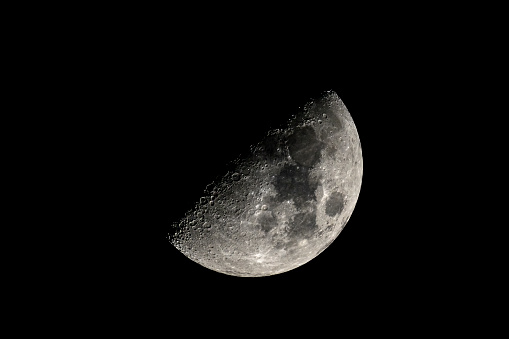 Partly illuminated moon in the dark night sky over Western Europe on January 18, 2024. The surface of the moon is clearly visible with various craters and seas.