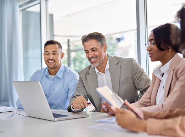 istock Happy diverse business employees team working at group meeting using laptop. 2004777380