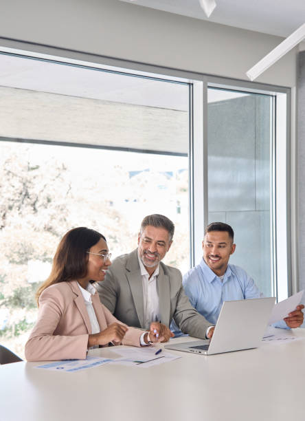 istock Happy diverse business employees team working at group meeting using laptop. 2004777409