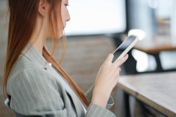 istock Businesswoman Checking Mobile Device in Office 2004779576