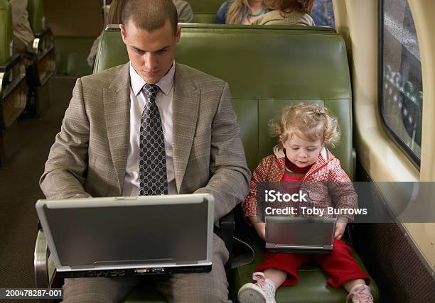 Padre E Figlia Sul Treno Utilizzando Un Computer Portatile E Lettore Dvd - Fotografie stock e altre immagini di Treno