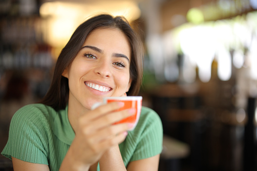 Happy woman with perfect smile drinking coffee