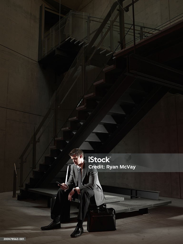 Junger Geschäftsmann, sitzen auf Bank am Treppe, mit Handy Uhr - Lizenzfrei Geschäftsmann Stock-Foto